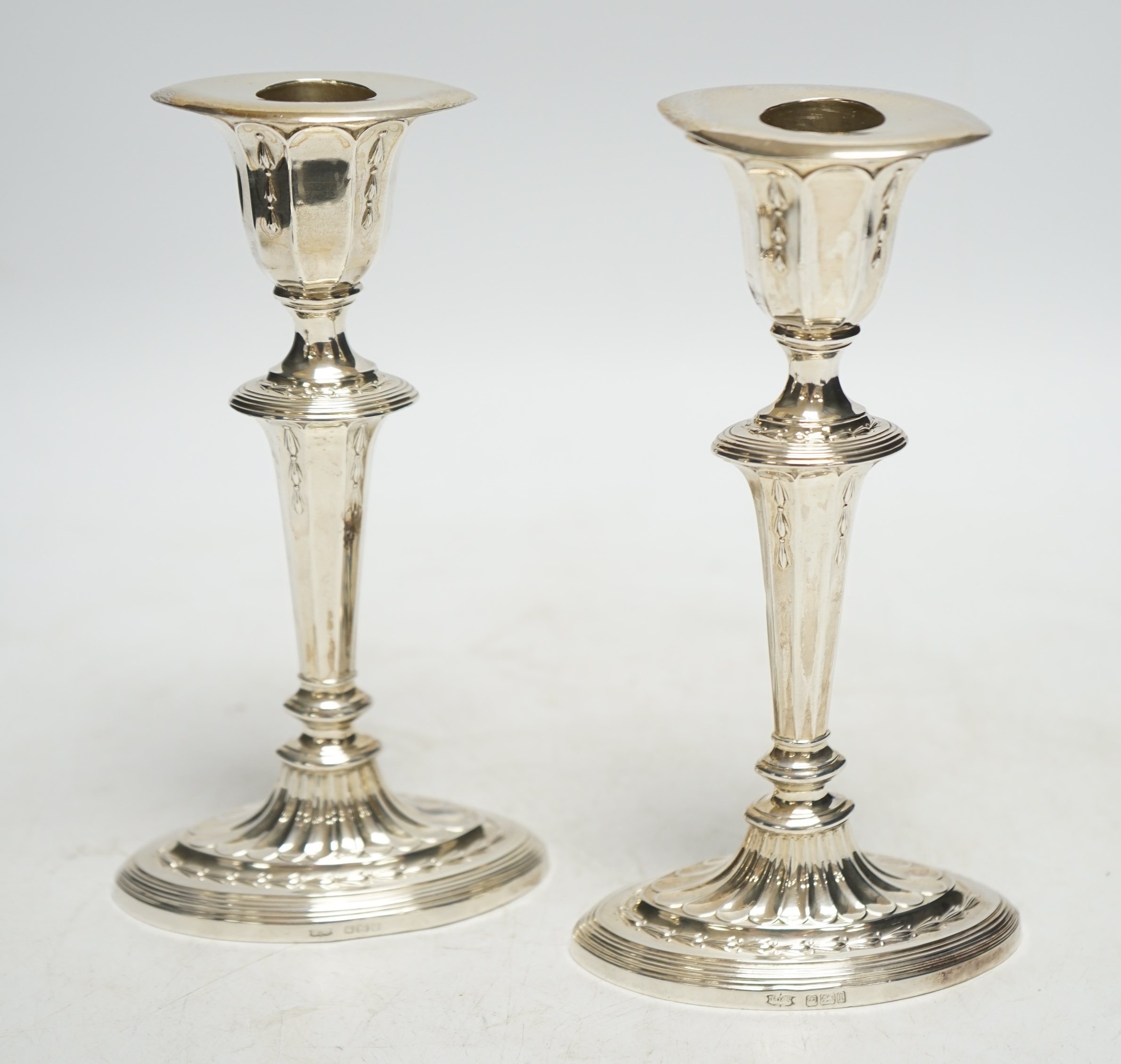 A pair of early 20th century silver oval candlesticks, by James Dixon & Sons, Ltd, Sheffield, 1903 & 1922, 17.2cm, weighted. Condition - fair